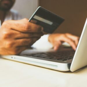Person shopping online with a card and laptop