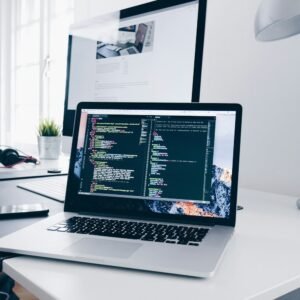 Laptop with code on a busy desk